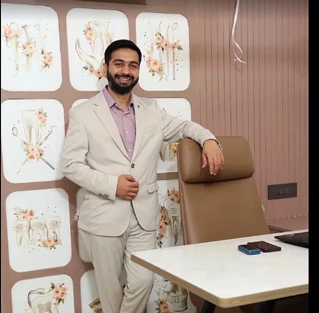 Dr. Vijay Makwana beside the consultation desk at V-Dent Dental Care, New Nikol, Ahmedabad